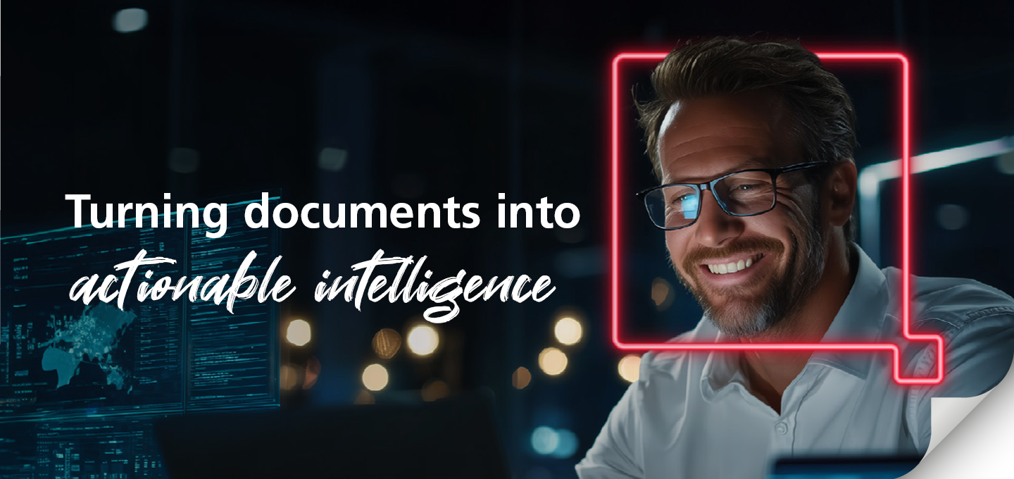 A smiling man in glasses works on a computer in a dimly lit office. Text reads: "Turning documents into actionable intelligence." A download icon is visible.
