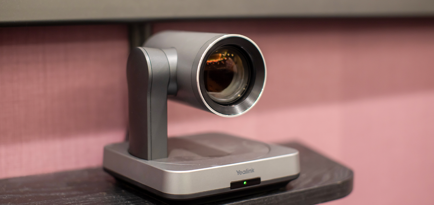 A camera mounted on a stand, positioned on a table, ready for photography or video recording.