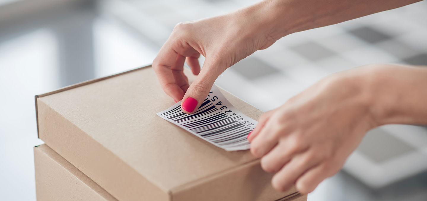 A person sticks a barcode on the box