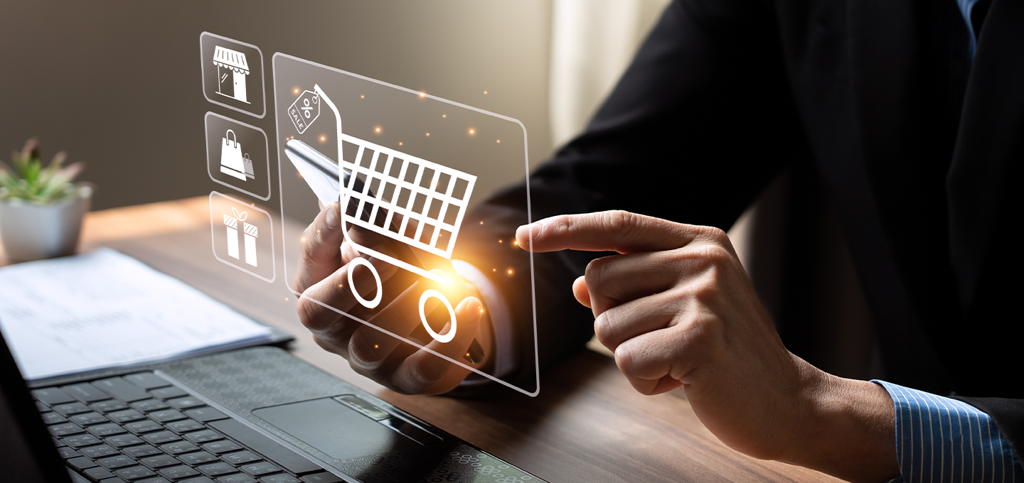 a person in business-wear shopping on a modern laptop, with a glowing shopping cart symbol overlaid.
