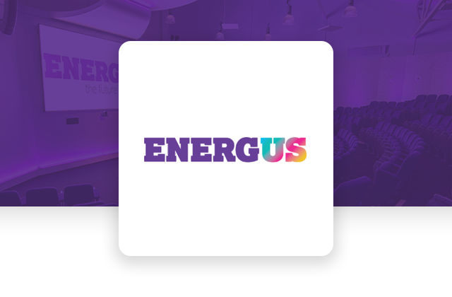 Energus logo displayed over a conference auditorium background, representing professional event management, business conferences, training sessions, and corporate events.