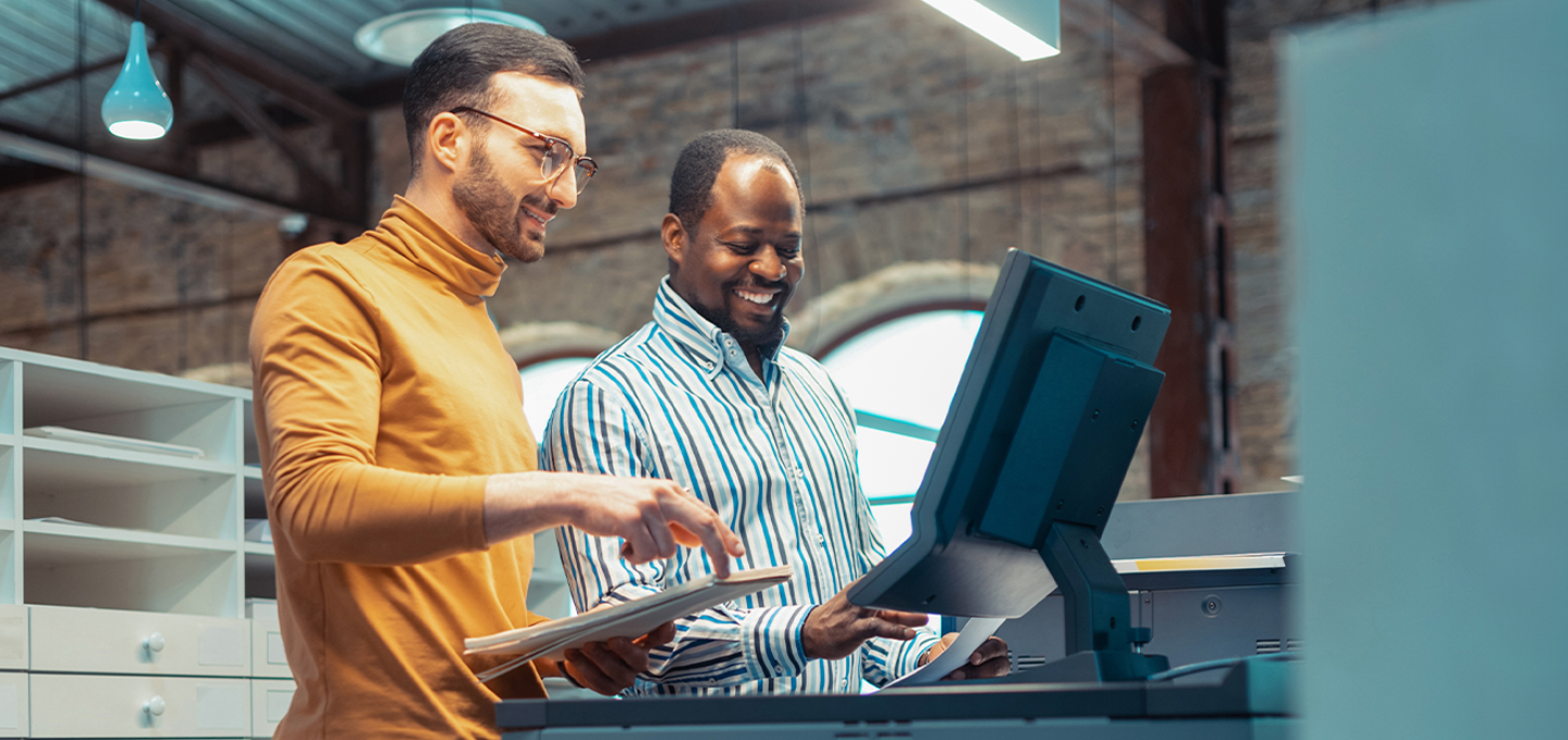 A woman is working at her desk as icons relating to document management appear next to her. She is reviewing a smart tablet held in her hand.