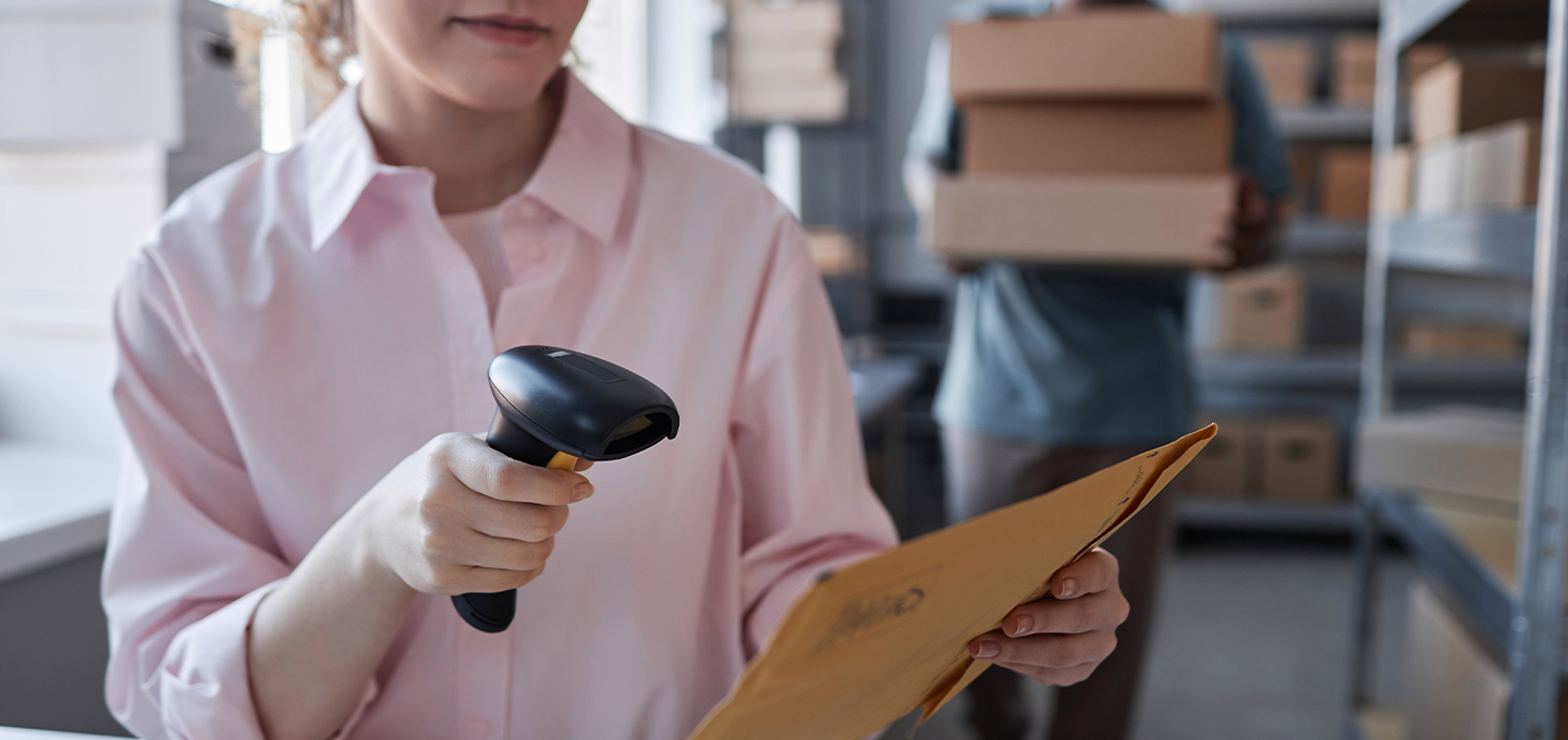employee scanning a parcel in a mailroom.