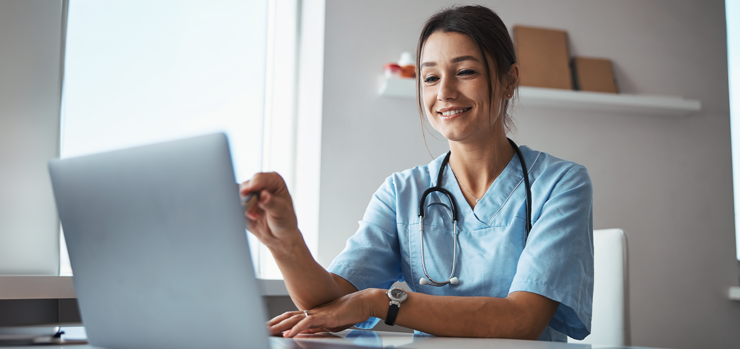 A doctor pointing at her laptop and evaluating what is shown on screen.